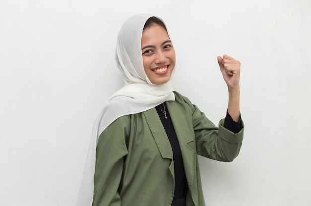 Donna asiatica che indossa l'hijab felice ed emozionato che celebra la vittoria che esprime grande energia di potere di successo ed emozioni positive