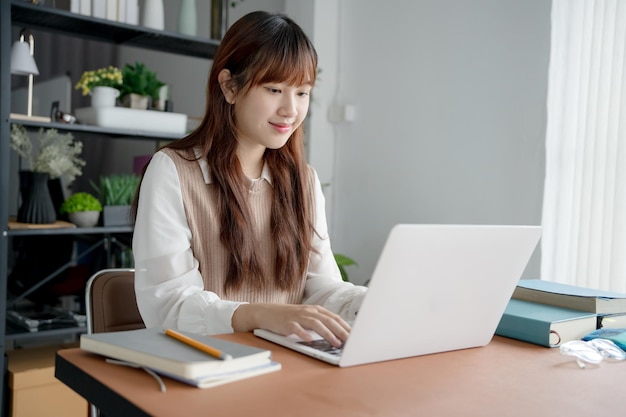 Donna asiatica che lavora con un laptop in soggiorno