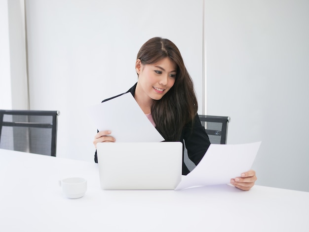 Donna asiatica che lavora in ufficio con il caffè