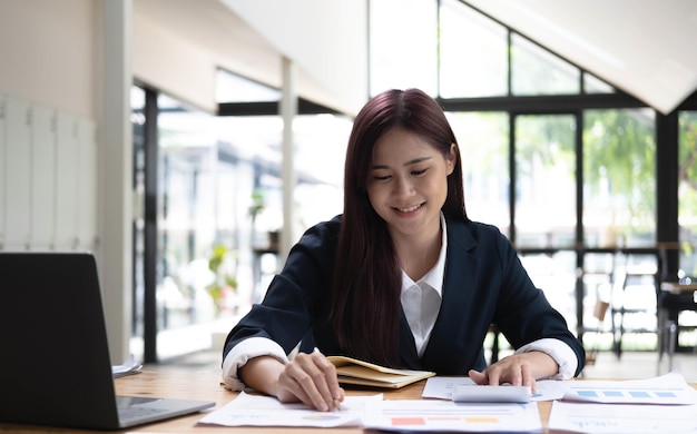 Donna asiatica che lavora su un computer portatileLavorare in ufficio con il concetto di laptop Giovane donna asiatica che inizia un'attività utilizzando un computer portatile