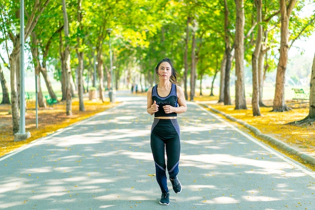 Donna asiatica che pareggia e corre nel parco