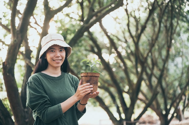 Donna asiatica che pianta alberi per l'ambiente