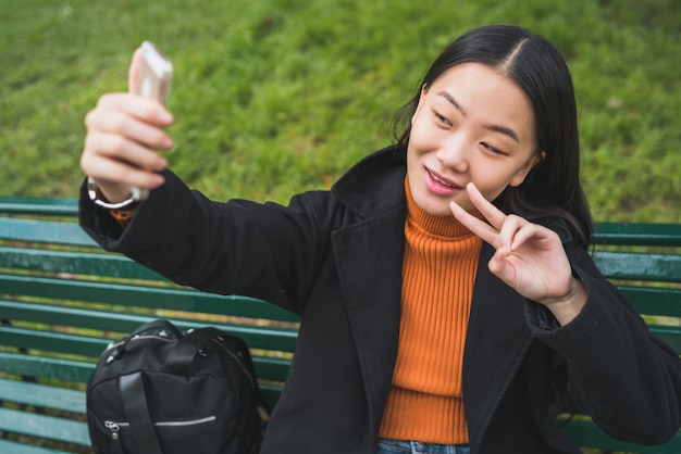 Donna asiatica che prende selfie con il telefono