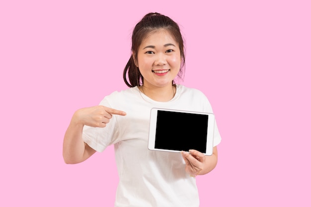 Donna asiatica che presenta il computer tablet schermo vuoto