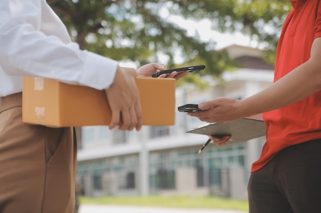 Donna asiatica che riceve il prodotto dal fattorino a casa Giovane proprietaria Donna che ordina il prodotto dall'applicazione per smartphone Donna con business online o concetto di PMI