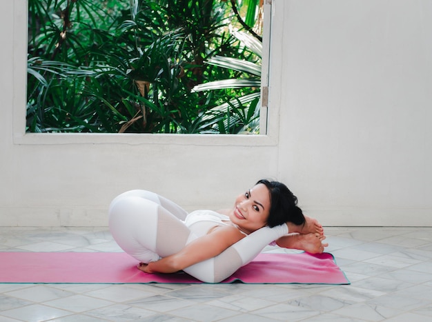 Donna asiatica che si esercita in casa a praticare yoga