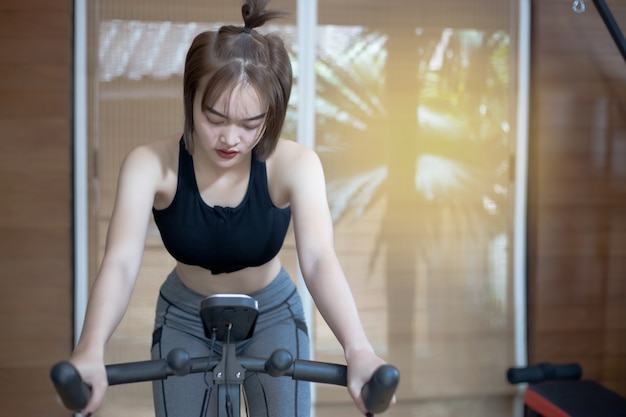 Donna asiatica che si esercita in palestra, allenamento della giovane donna nella forma fisica per lei sana