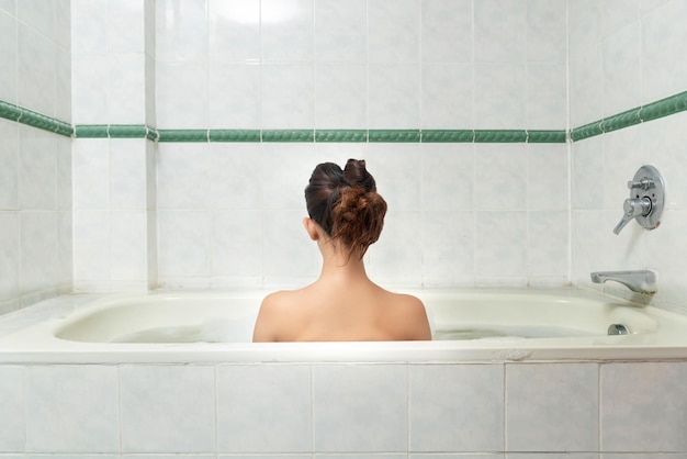 Donna asiatica che si rilassa sulla vasca da bagno