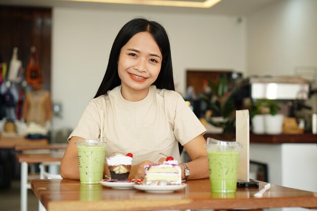 Donna asiatica che sorride felicemente in un caffè