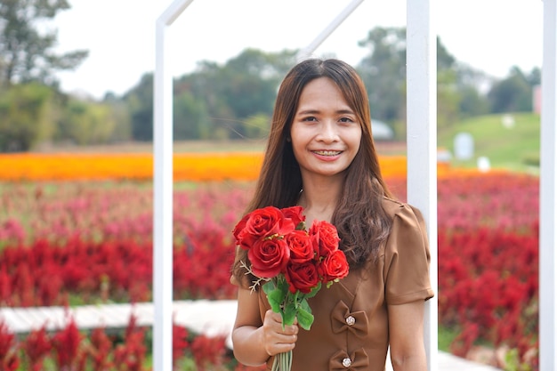 Donna asiatica che sorride felicemente tra i bei fiori