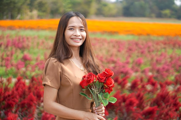 Donna asiatica che sorride felicemente tra i bei fiori