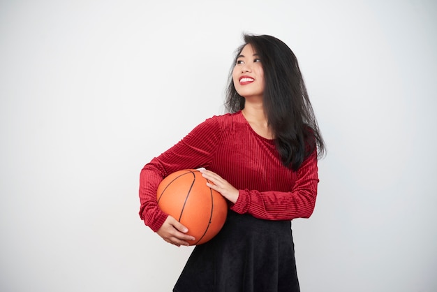 Donna asiatica che sta con la palla di pallacanestro