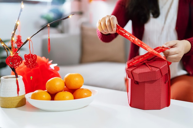 Donna asiatica che tiene la confezione regalo rossa grata presente Nuovo anno lunare Festa tradizionale cinese Cultura del capodanno lunare