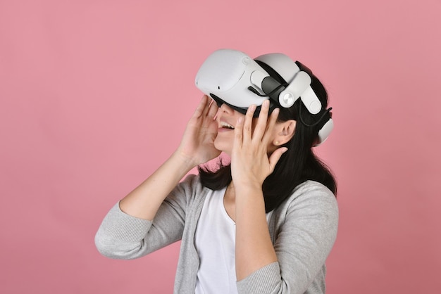 Donna asiatica che usa gli occhiali vr Guardare film e giocare ai videogiochi dalle cuffie per realtà virtuale Giovane donna straordinaria con la nuova esperienza della tecnologia vr Scatto in studio