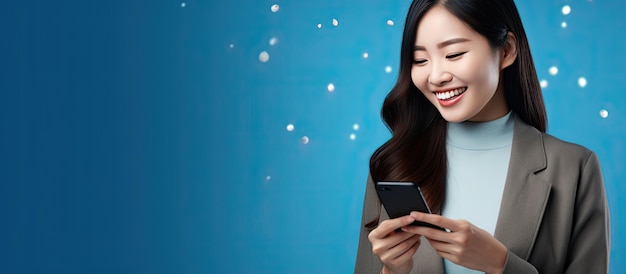 Donna asiatica che utilizza la messaggistica dell'app per smartphone sui social media che punta via con sfondo blu e copia spazio per la pubblicità