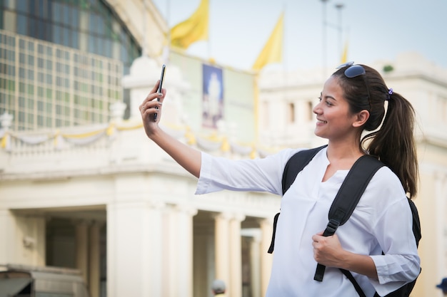 Donna asiatica che viaggia con il cellulare