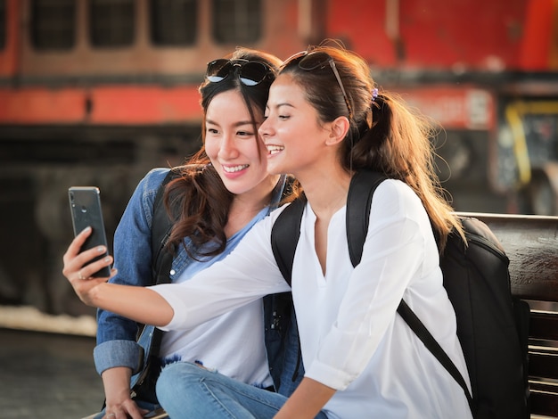 Donna asiatica che viaggia con il cellulare