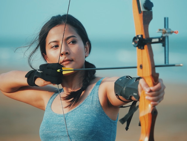 Donna asiatica con arco Tiro con l&#39;arco