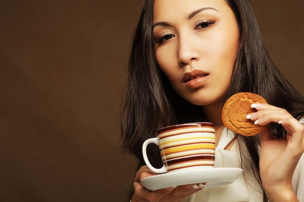 donna asiatica con caffè e biscotti.