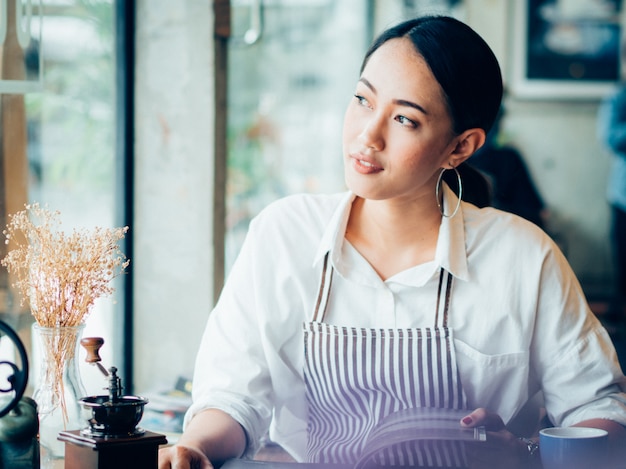 Donna asiatica con caffè nella caffetteria