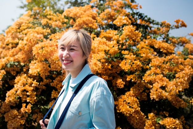 Donna asiatica con fiori d&#39;arancio in background