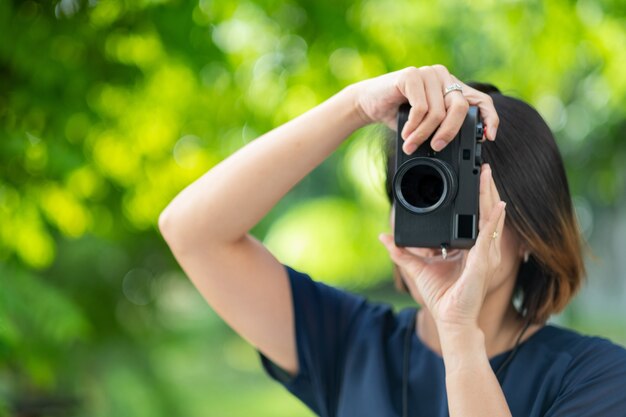 Donna asiatica con in mano una macchina fotografica, fotografo professionista