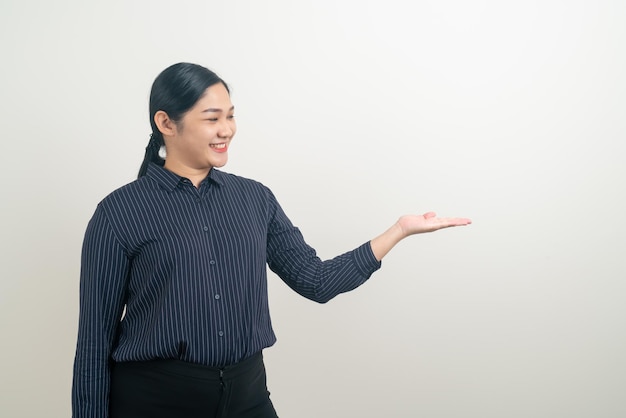 Donna asiatica con la mano che presenta sul muro