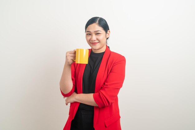 Donna asiatica con la mano che tiene la tazza di caffè su sfondo bianco