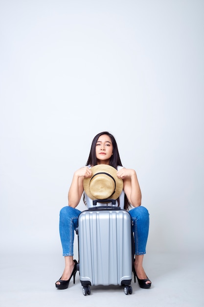 Donna asiatica con la valigia luminosa