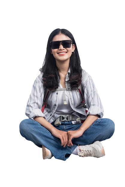 Donna asiatica con occhiali da sole e zaino seduto