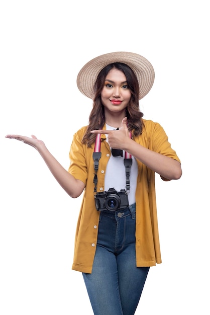 Donna asiatica con un cappello e una macchina fotografica con il palmo aperto che punta a qualcosa