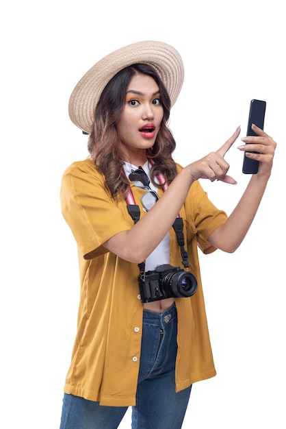 Donna asiatica con un cappello e una macchina fotografica utilizzando un telefono cellulare