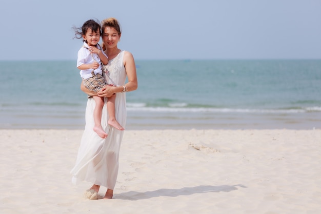 Donna asiatica e figlio sulla spiaggia tropicale