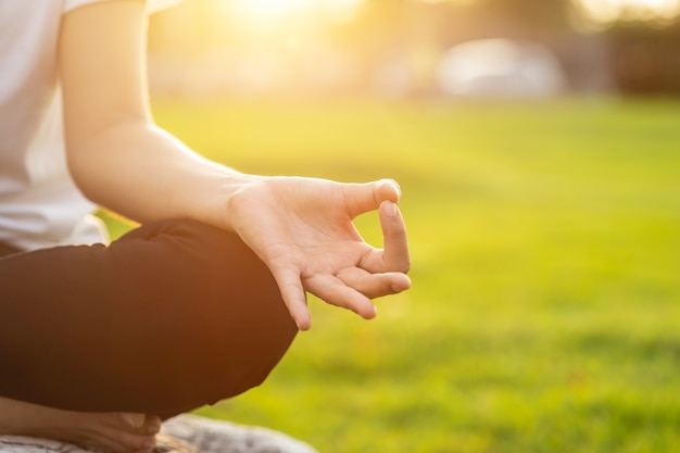 Donna asiatica facendo esercizi di yoga nel parco