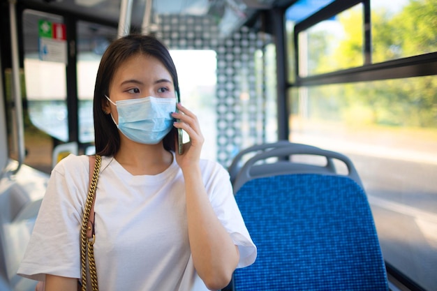 Donna asiatica fare un giro in autobus o tram di trasporto pubblico