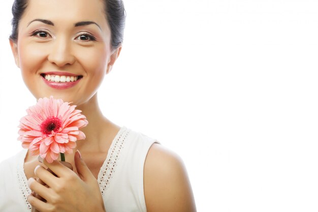 Donna asiatica felice che tiene una gerbera rosa