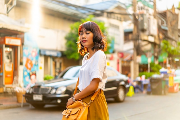 Donna asiatica felice e bella che viaggia a Khao Sarn Road, Tailandia