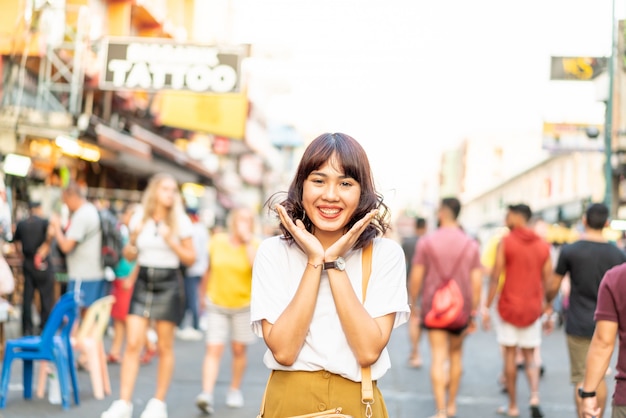 Donna asiatica felice e bella che viaggia a Khao Sarn Road, Tailandia