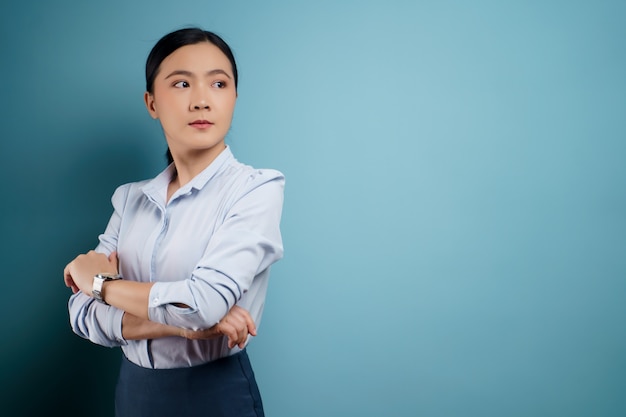 Donna asiatica felice sorpresa in posa sull'azzurro.