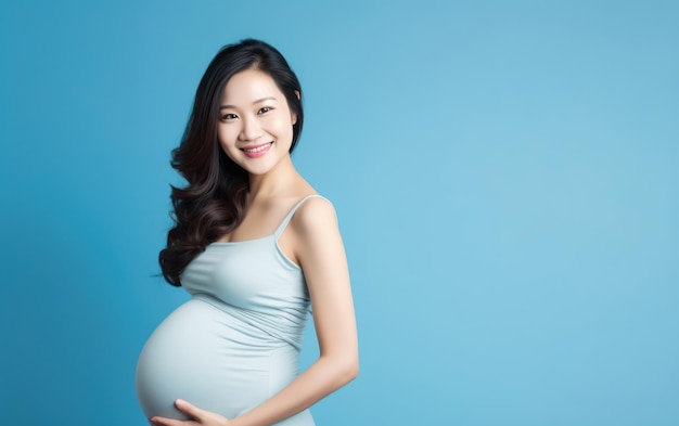 donna asiatica incinta felice che tocca la sua pancia