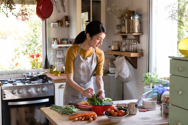 Donna asiatica intenta a cucinare in cucina