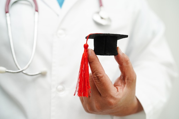 Donna asiatica medico che tiene il cappello di laurea in ospedale Concetto di educazione medica