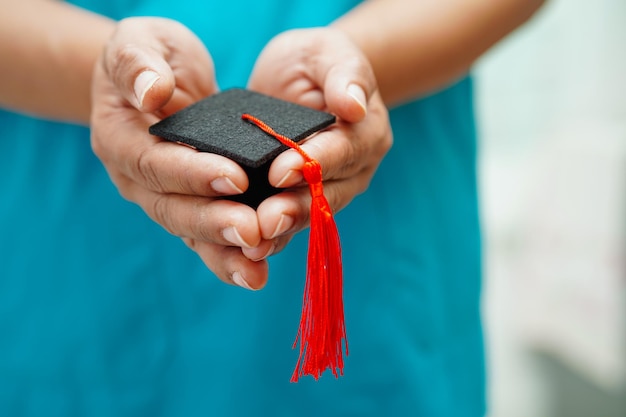 Donna asiatica medico che tiene il cappello di laurea in ospedale Concetto di educazione medica