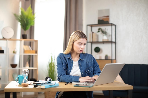 Donna asiatica seduta alla scrivania e digitando sul computer portatile