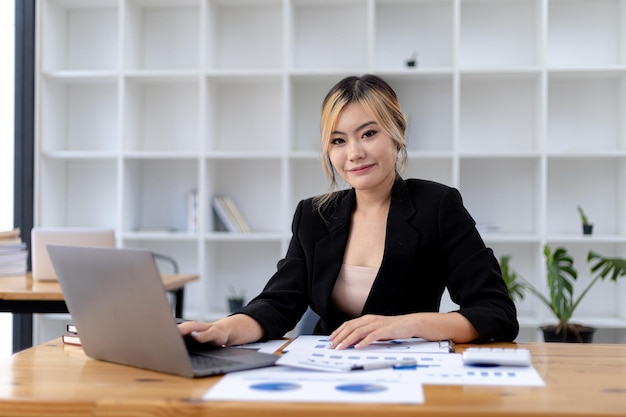 Donna asiatica seduta in un ufficio privato, è una giovane donna d'affari, leader femminile, donna asiatica che accetta di essere una leader e leader, donna che lavora. Concetto di donna d'affari.