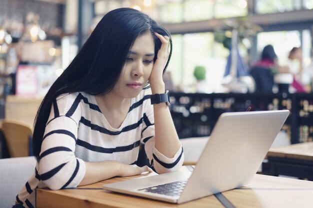 Donna asiatica seria e frustrata che pensa al problema a lavorare un compito difficile