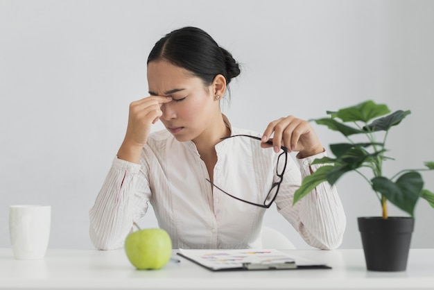 Donna asiatica stanca che si siede nell'ufficio