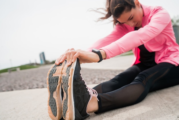 Donna atletica che allunga le gambe prima dell'esercizio.