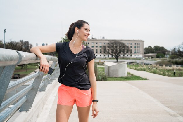 Donna atletica che ascolta la musica su una pausa dall'allenamento.