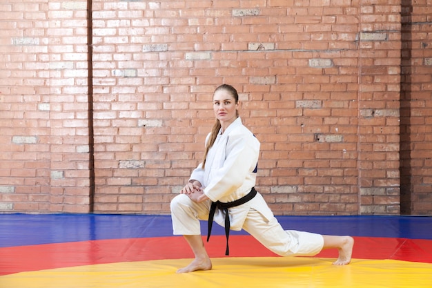 Donna atletica di karate in kimono bianco con cintura nera